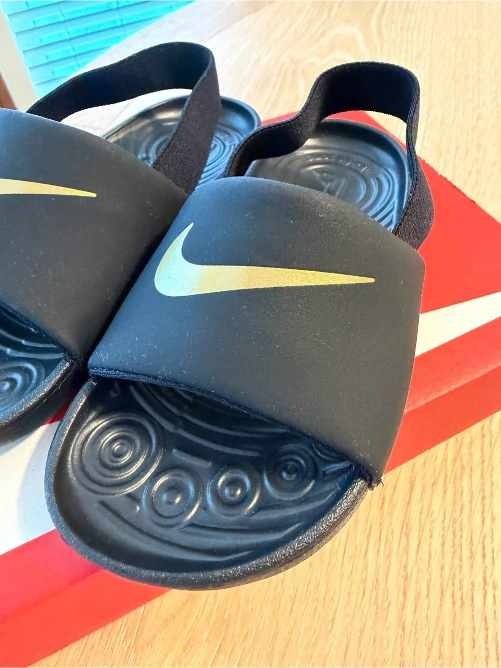 Nike Kids Black Slides with Gold Swoosh and Heel Strap